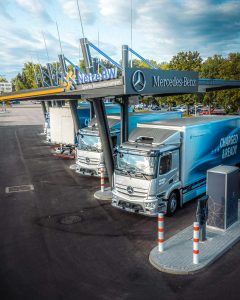 Modern Mercedes eActros trucks idle at a European depot, illustrating detention and demurrage driver waiting time