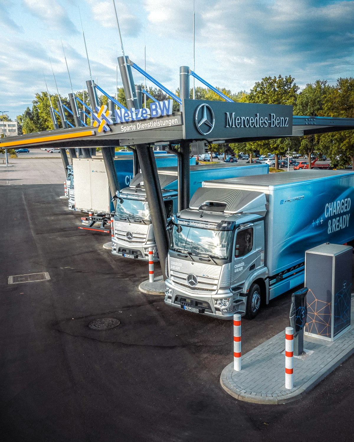 Modern Mercedes eActros trucks idle at a European depot, illustrating detention and demurrage driver waiting time