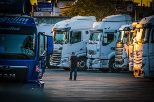 Row of European articulated lorries parked in a distribution centre yard